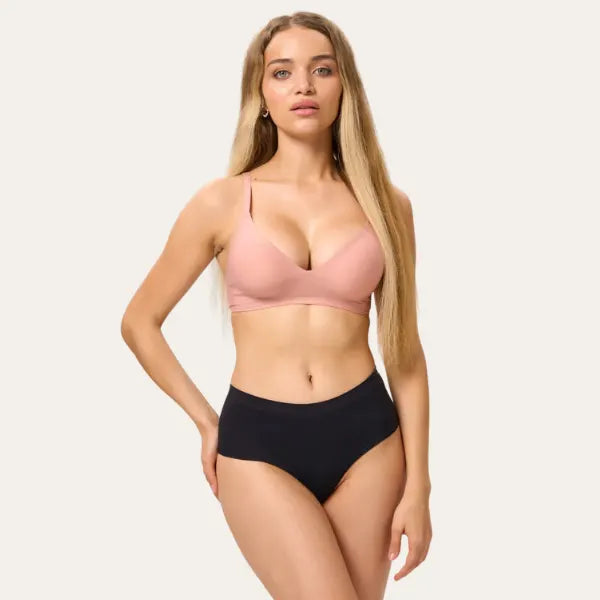 Modelo usando conjunto de lingerie com bralette sublime rosé e calcinha preta de cintura média