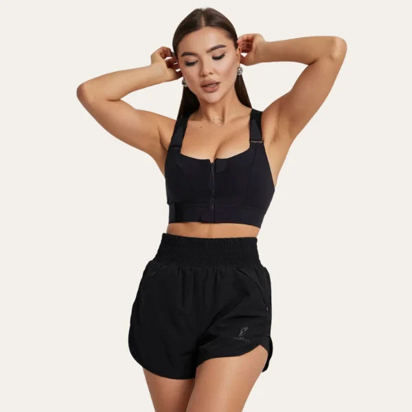 Modelo a usar o soutien desportivo preto Alba Le Liss com calções de treino, destacando o design moderno e o suporte ideal para atividade física.