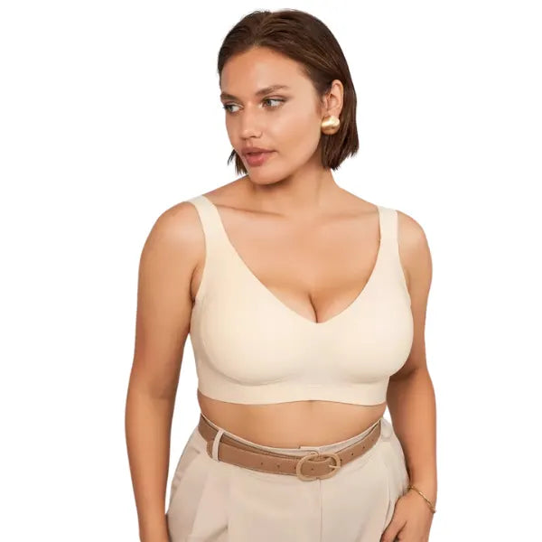 Modelo a usar soutien de sustentação Firm bege sem aro e calça de cintura subida em tom neutro.