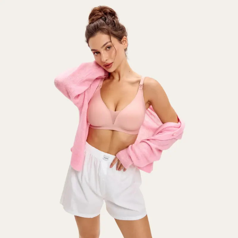 Modelo a usar o soutien para amamentar Serene rosa com camisa aberta, vista frontal, reforçando o uso pós-parto.