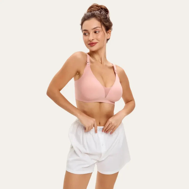 Modelo a usar o soutien para amamentar Serene rosa, vista frontal, com copas lisas, sem aro e decote em V com inserção em tule.