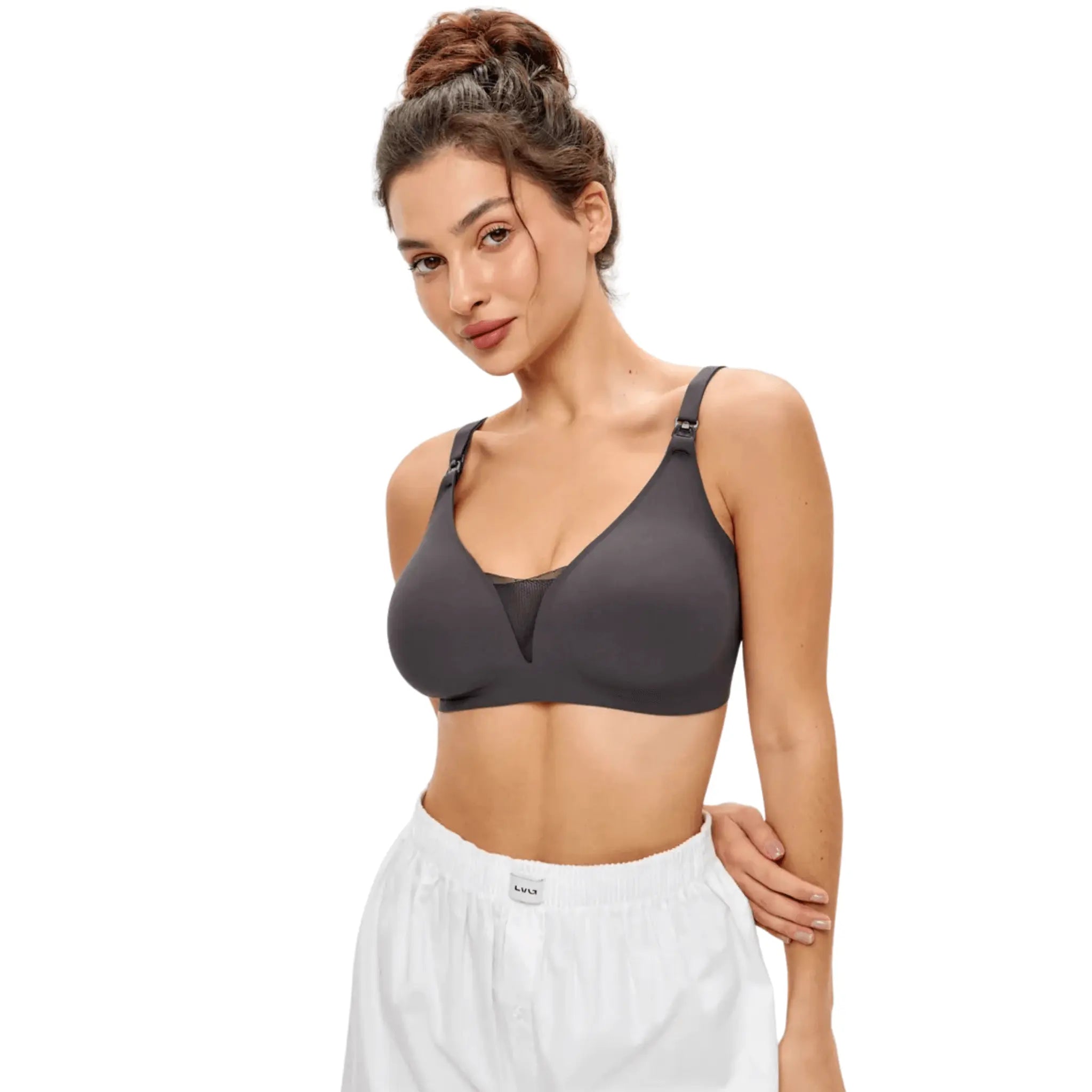 Mulher usando sutiã de amamentação preto. O decote em V com tule e os fechos nas alças são visíveis.