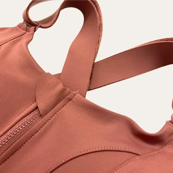 Detalhe das alças cruzadas em X do soutien desportivo Alba terracota visto em ângulo superior